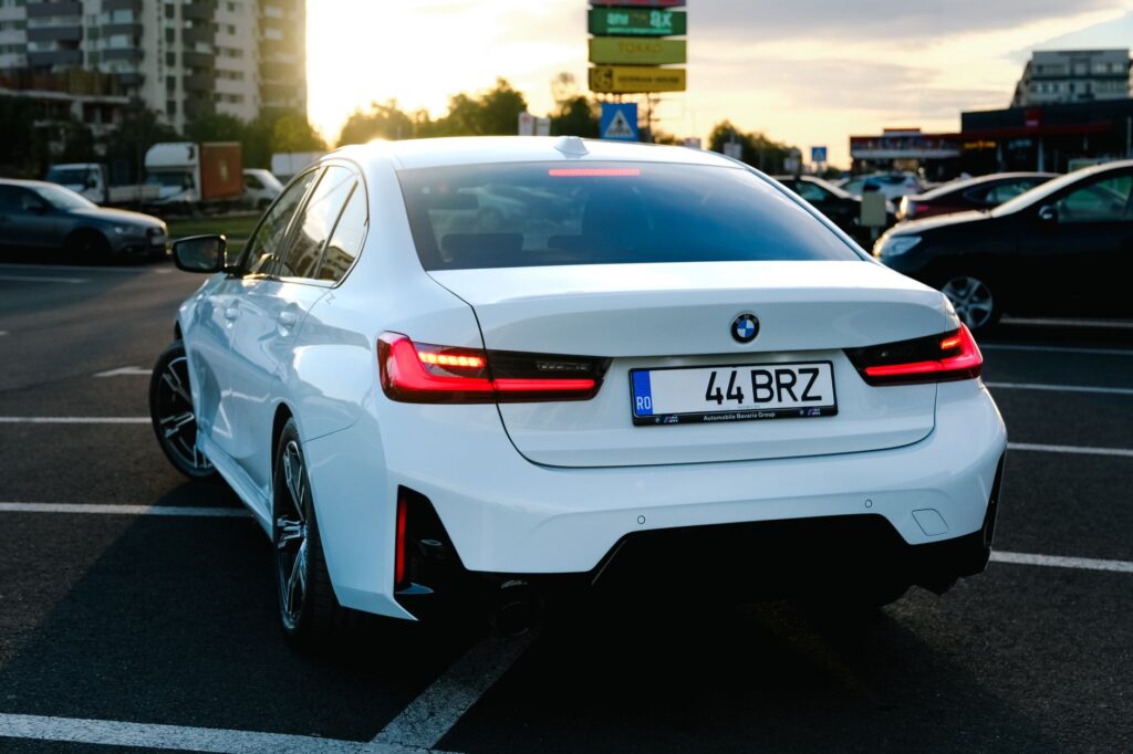 Dealer fotografujący auto smartfonem na placu komisowym